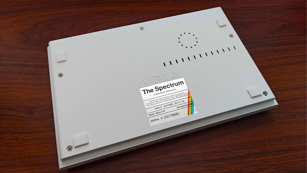The Spectrum White Edition upsidedown on woodgrain desk.