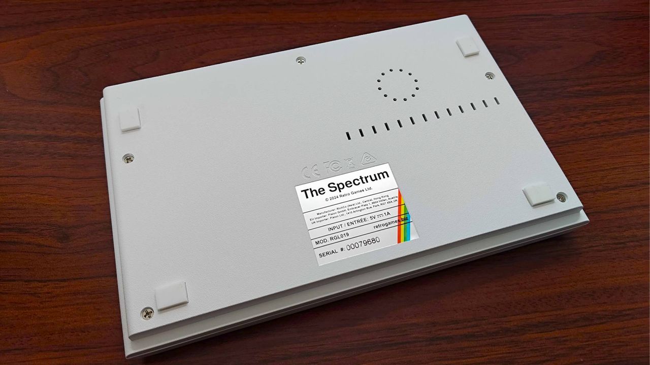 The Spectrum White Edition upsidedown on woodgrain desk.