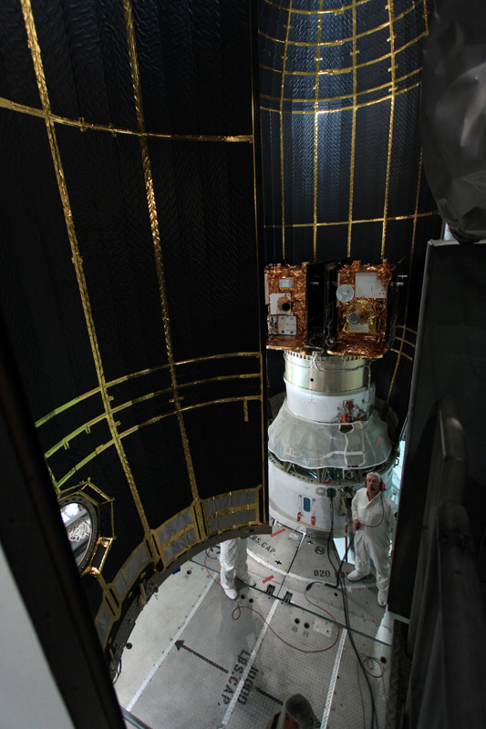 At Space Launch Complex 17B on Cape Canaveral Air Force Station in Florida, the second half of the clamshell-shaped Delta payload fairing swings into place around NASA&#039;s twin Gravity Recovery and Interior Laboratory spacecraft under the scrutiny of a spac