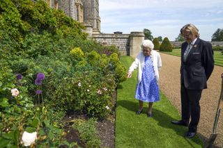 Queen Elizabeth II views a flower bed with President of the Royal Horticultural Society, Keith Weed, after he presented her with a Duke of Edinburgh rose, named in memory of her late husband Prince Philip, the Duke of Edinburgh, at Windsor Castle in Windsor, west of London, on June 2, 2021