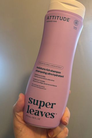 a hand holding attitude shampoo