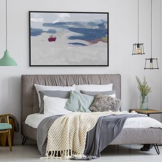 grey bedroom walls with grey bed and abstract artwork