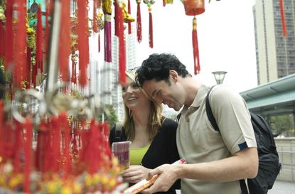 China, Hong Kong, couple looking at incense by Po Lim Temple