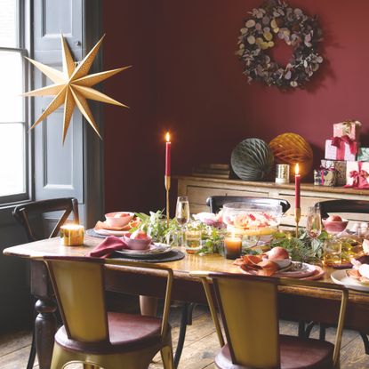 christmas dining table with red wall and wreath