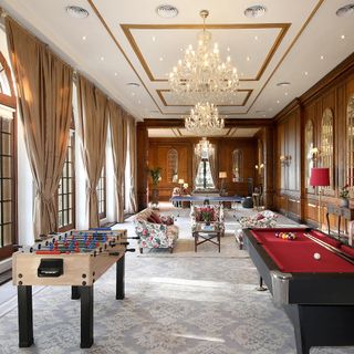 Games room with chandelier and curtains on window