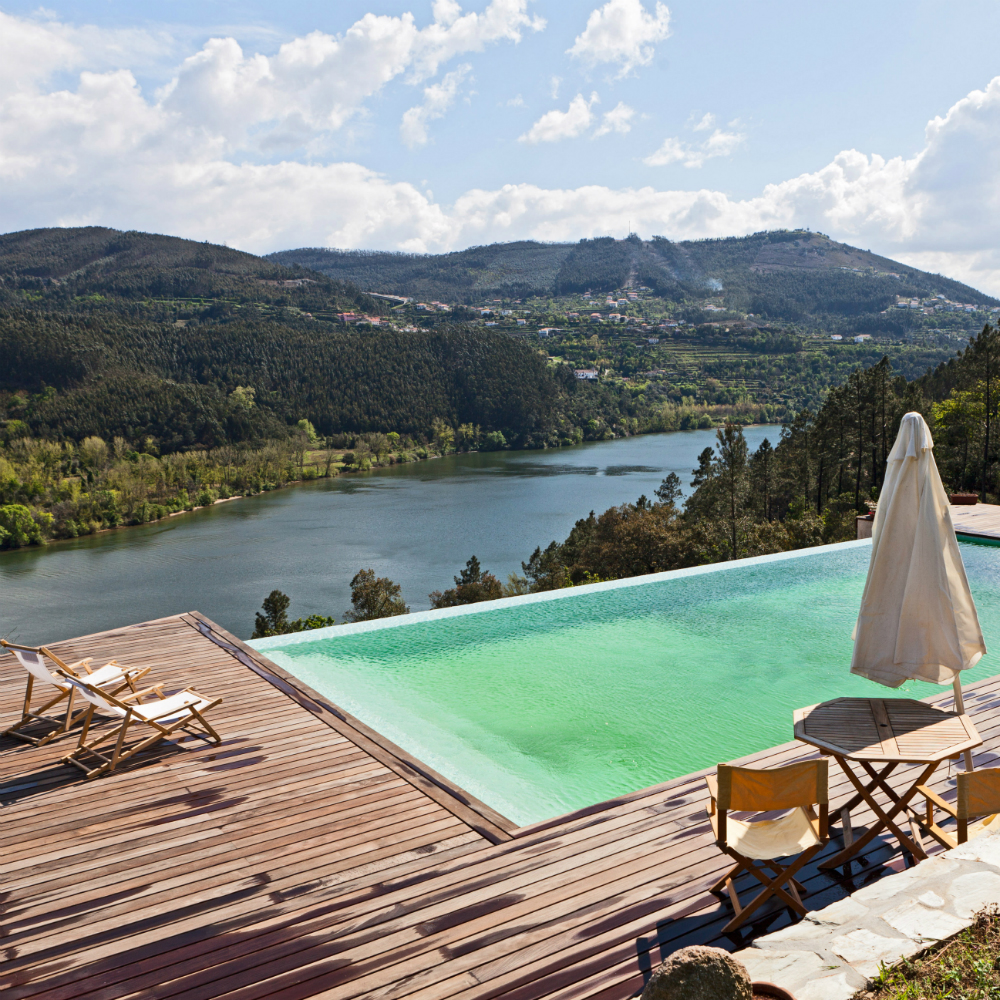 swimming pool with pool lounge chairs and river view