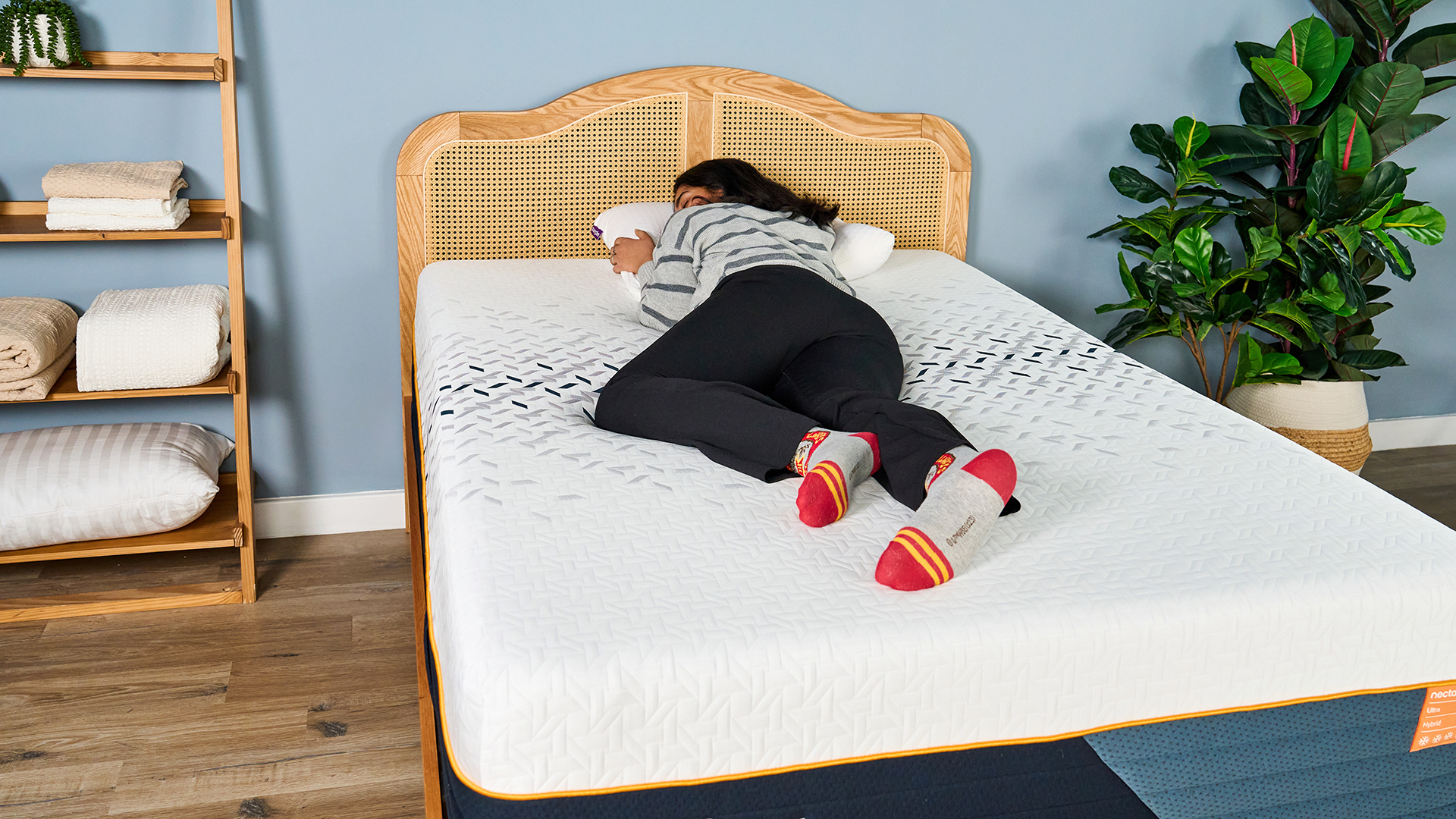 A female Tom's Guide mattress tester lying comfortably on her side on the Nectar Ultra Hybrid mattress