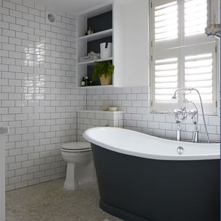 bathroom with white tiles on wall and bathtub