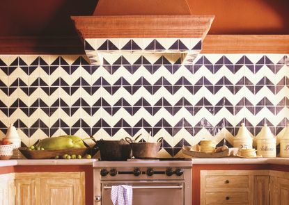 A kitchen with orange ceiling, and zig zag wall toles