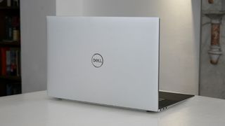 En vit, stilren Dell XPS 17 (2022) står på ett vitt skrivbord i en ljus kontorsmiljö.