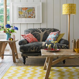 room with grey armchair wooden furniture and yellow lamp