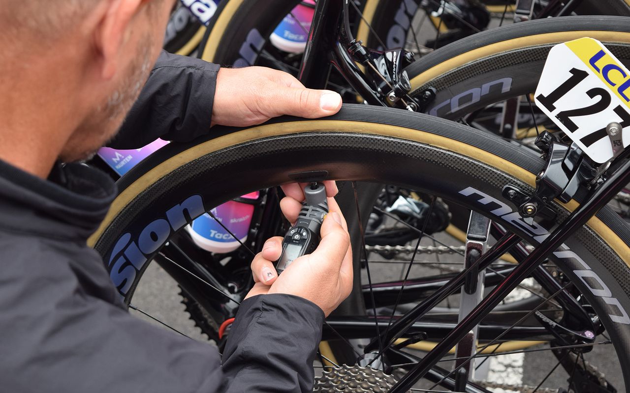 An EF Education First mechanic checks tyre pressures ahead of a stage start