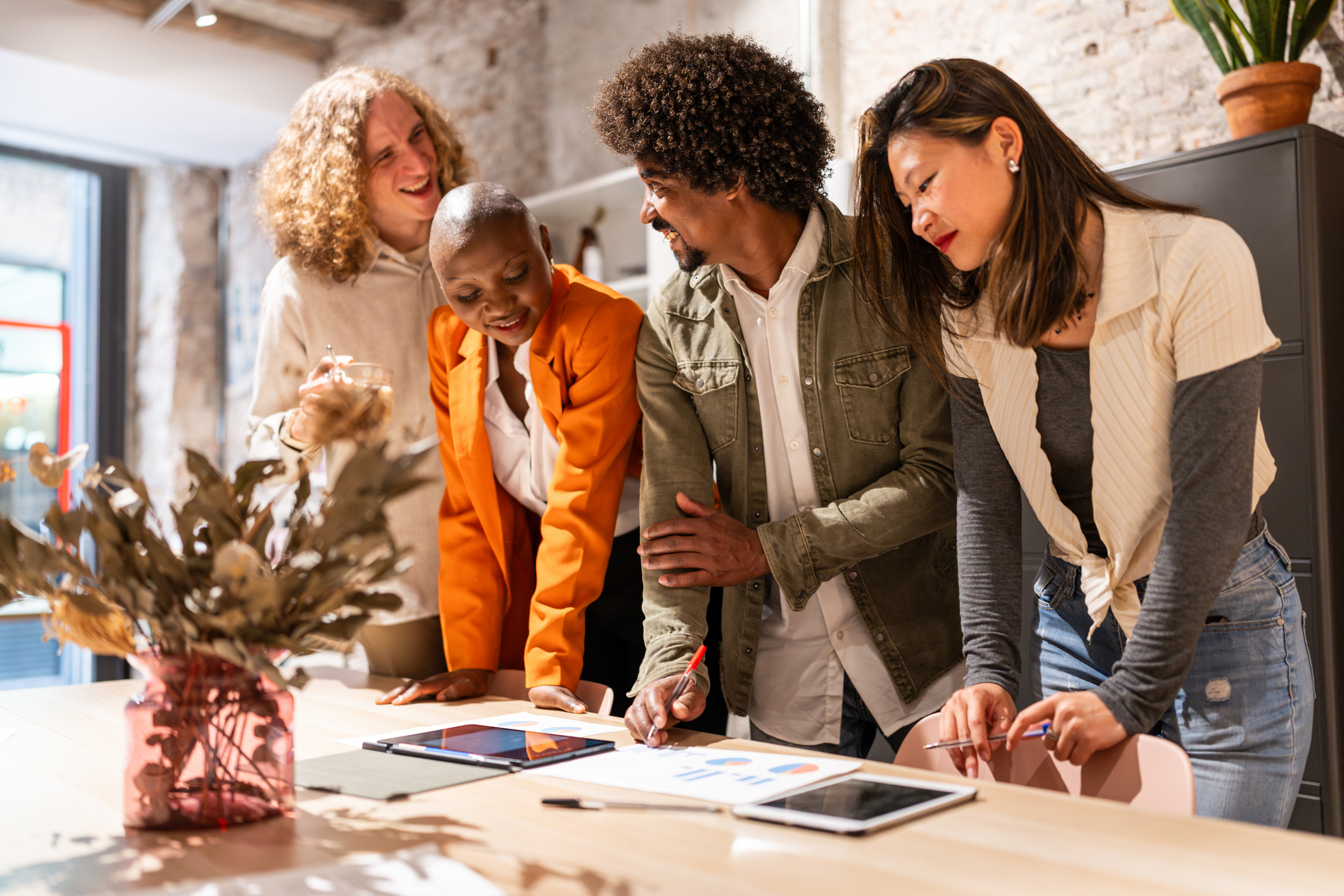 Friends gather around a table discussing investment