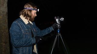 Mike Harris uses a tripod, camera, and remote shutter release at night, while shooting astro