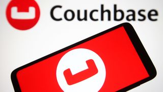 Couchbase logo on a smartphone set against a white background with another Couchbase logo sprawled across it