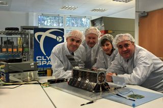 Clyde Space scientists, the proud parents of Scotland’s first satellite, UKube-1, pose with the small spacecraft, which is set to launch in 2013.