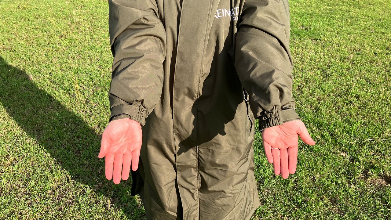 Lady wears Reincoat Pro in a field showing close up of cuffs