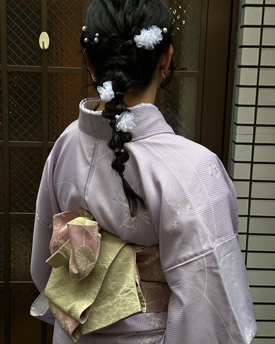 Allison Ho wears a pale pink kimono with white floral hair accessories while visiting Asakusa, Japan
