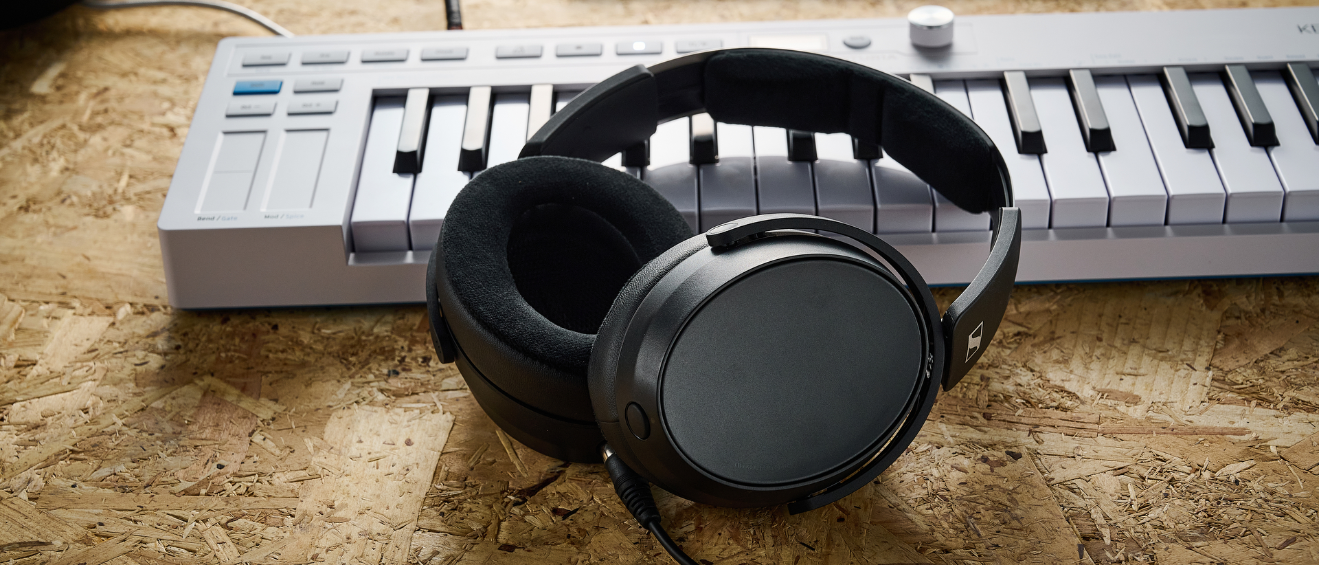 A pair of Sennheiser HD 480 Pro studio headphones leaning against a MIDI keyboard