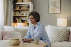 A woman working on a laptop in her living room