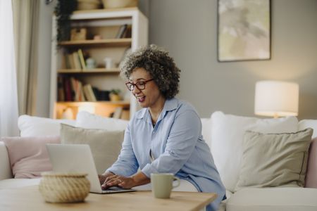 A woman working on a laptop in her living room