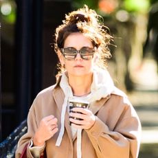 Katie Holmes carrying her Metier red bag and wearing wide-leg jeans and Autry sneakers