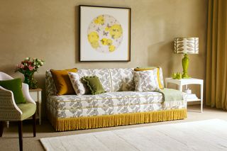 Yellow patterned click-clack couch for a small living room painted golden yellow, with green and white soft furnishings and accents.