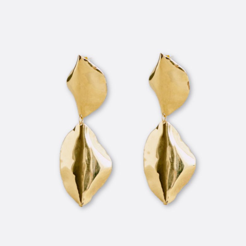 A cutout of two gold drop statement earrings