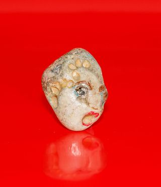 stone face on a red background