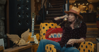 A picture of Steven Tyler speaking on a telephone