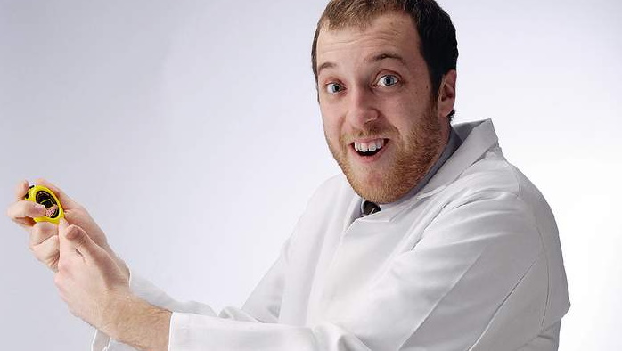 Matt Hanson in a lab coat holding up a stopwatch