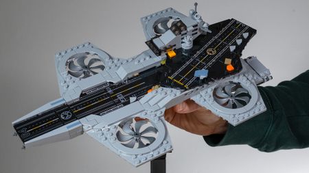 Hand holding The Avengers Helicarrier (76295) 3/4 view on a neutral background 