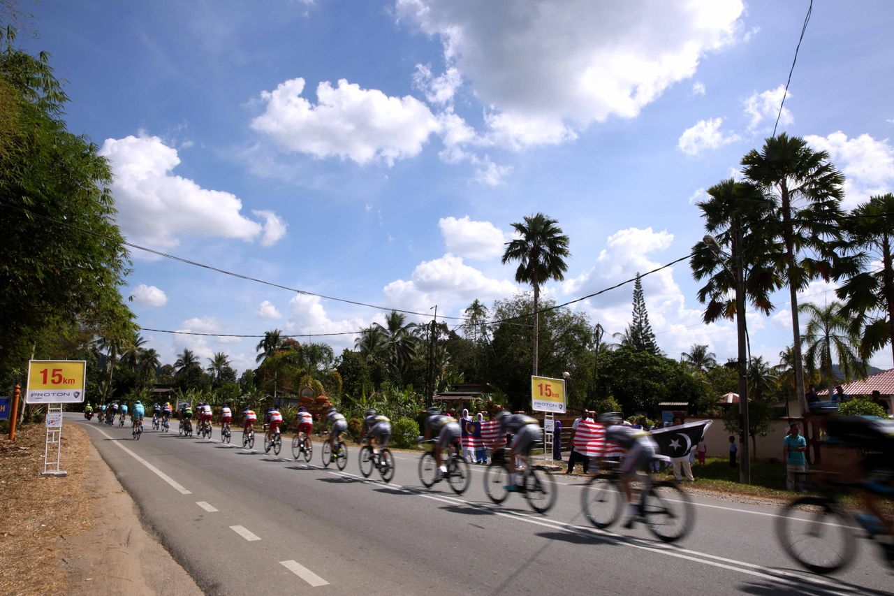The peloton speed past