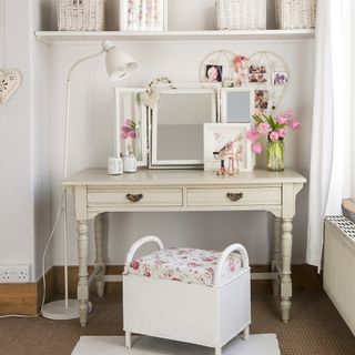 bedroom with white wall and wooden dressing table with white lamp light and white chair