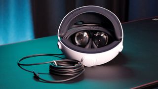 PSVR 2 Review Image showing the headset sat on a table, allowing you to see the lenses and USB-C cable