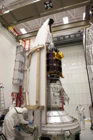 Engineers at NASA's Wallops Flight Facility in Virginia encapsulate NASA's Lunar Atmosphere and Dust Environment Explorer (LADEE) spacecraft into the fairing of the Minotaur V launch vehicle nose-cone.