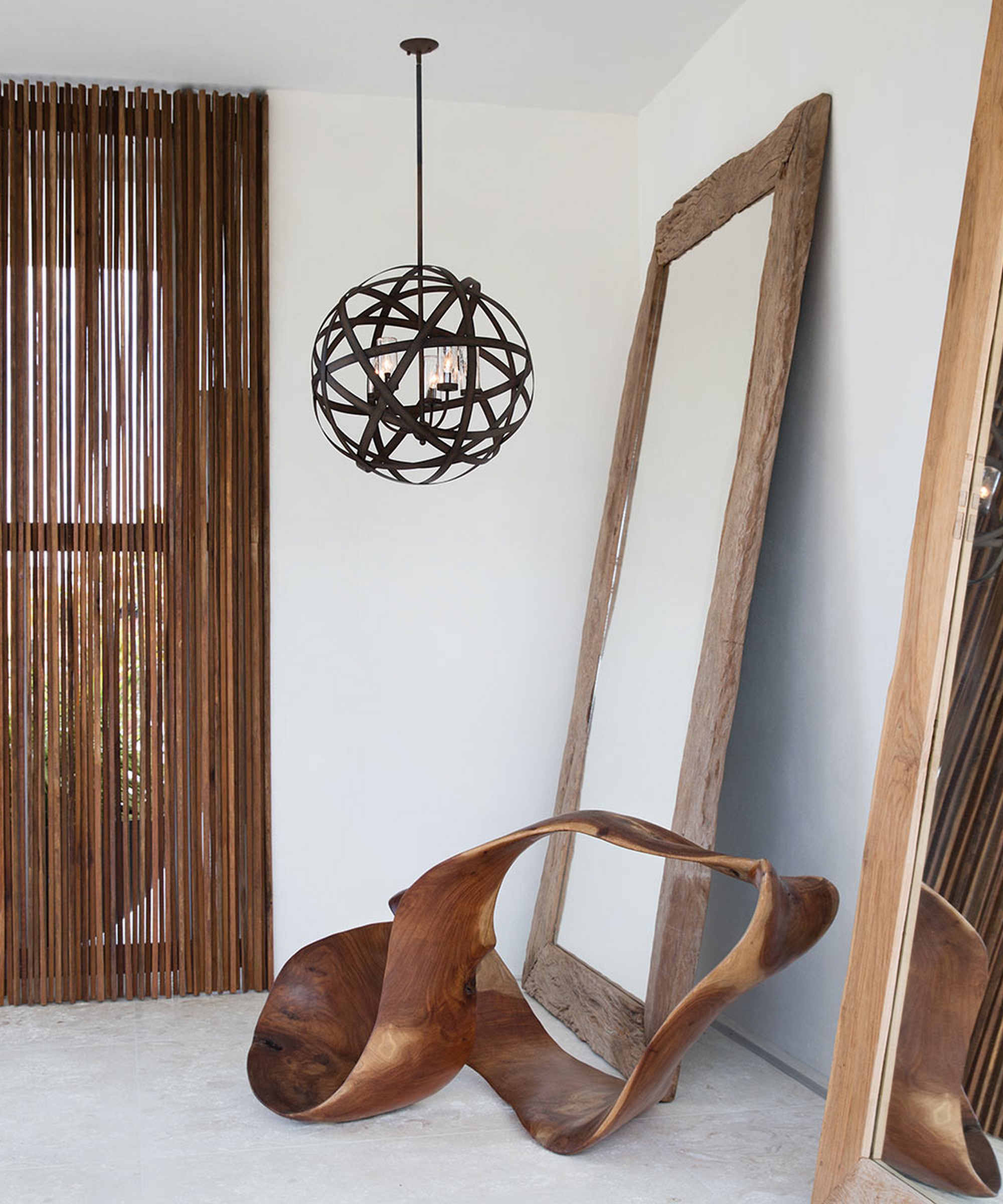 modern hallway with wire sculptural pendant light, 2 large wooden mirrors, wooden sculpture on floor