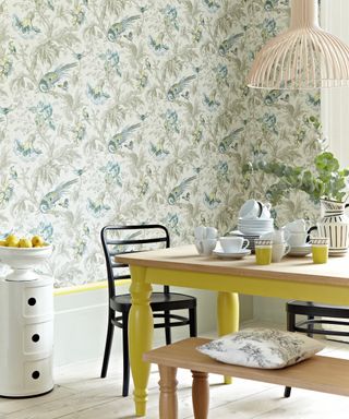 Yellow painted table with green wallpaper