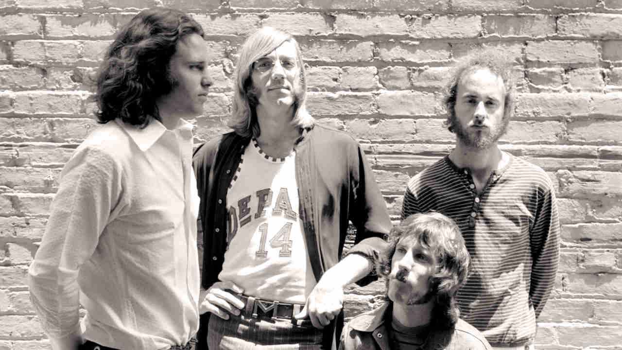 The Doors posing for a photograph in front of a brick wall in 1968