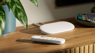 Google TV Streamer and remote placed on a wooden tabletop