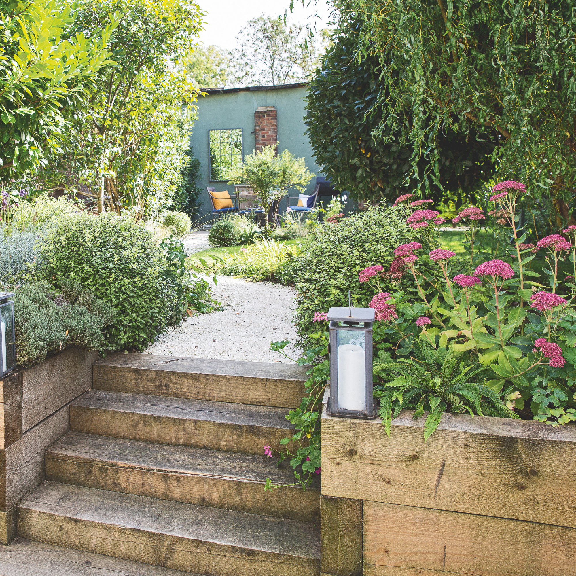 Steps up between the raised beds to the gravel path leading through the garden to the seating area at the end of the garden.