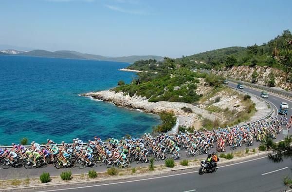 The peloton races along the coastline.