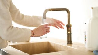Person pouring boiling water from a tap