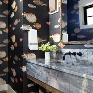 A bathroom with a wallpaper with coastal motifs