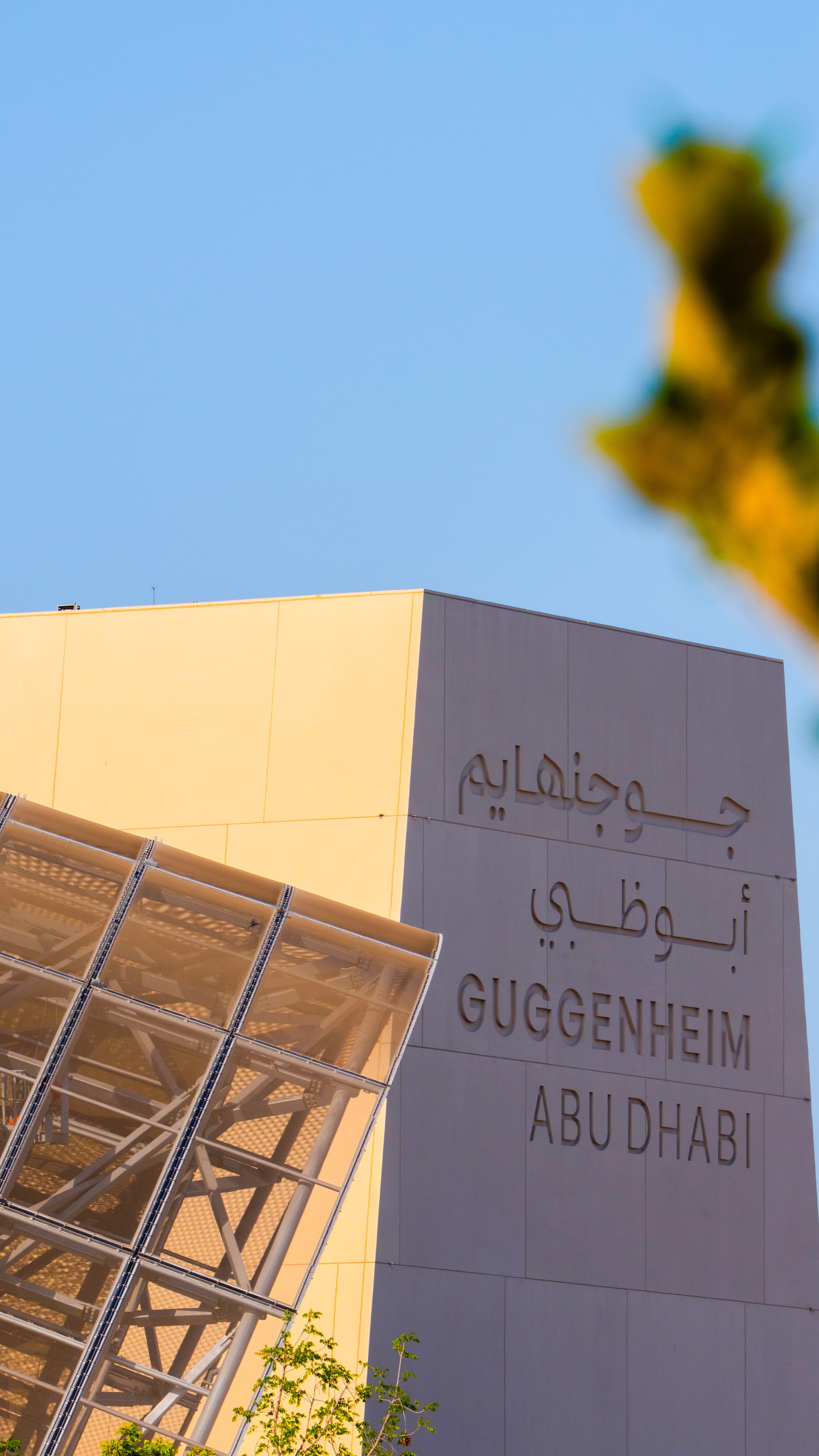 Guggenheim Abu Dhabi exterior images featuring a geometric assemblage of volumes made from steel glass timber and stone