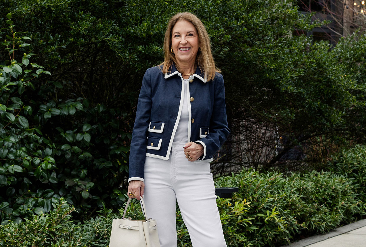 A Nordstrom stylist wearing a navy jacket and white jeans.