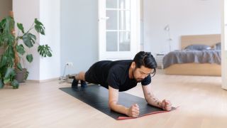 Man performs plank core exercise