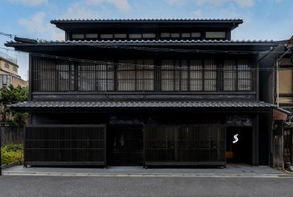 View of the black front facade of Tadao Ando's Shinmonzen hotel in Kyoto during the day