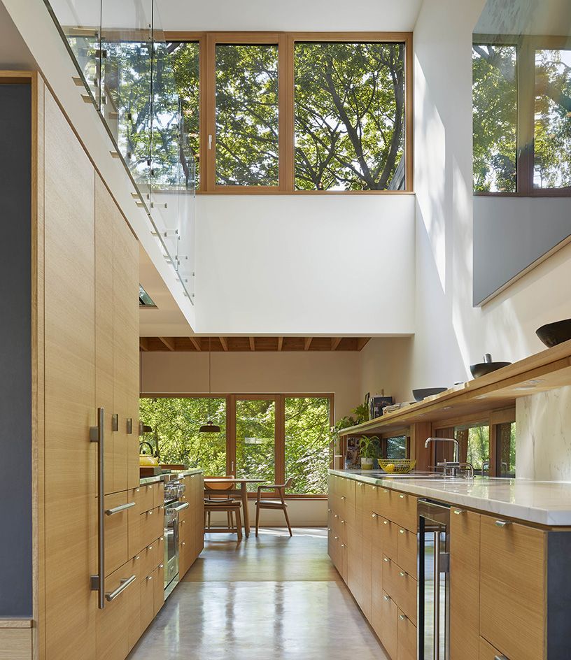 double height house interior with pale wood kitchen