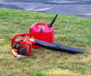 Leaf blower and gas can on a lawn